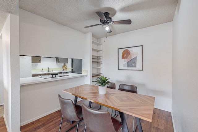 dining area with dark wood-type flooring, ceiling fan, built in shelves, and a textured ceiling