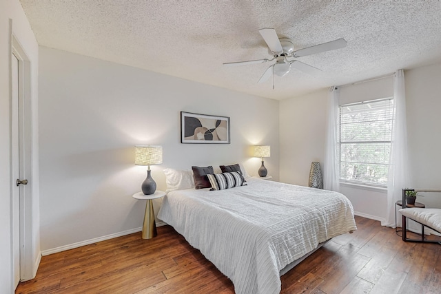 bedroom with hardwood / wood-style flooring, ceiling fan, and a textured ceiling