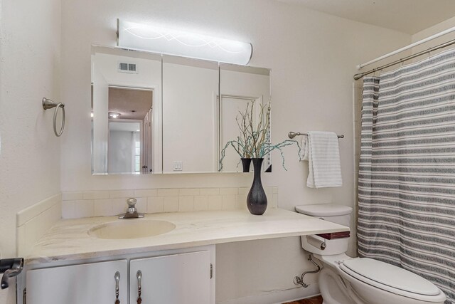 bathroom featuring vanity, toilet, and a shower with shower curtain