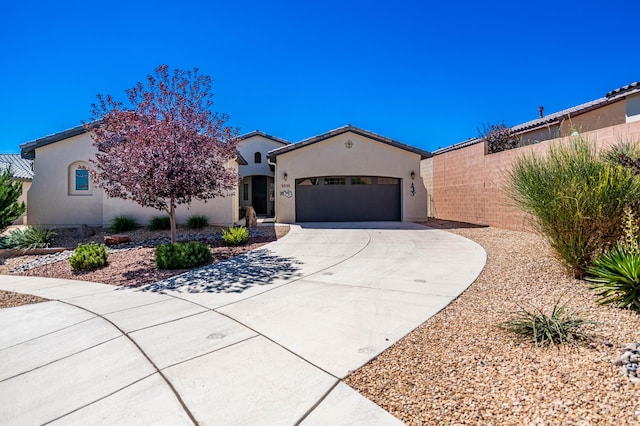 mediterranean / spanish-style home with a garage, concrete driveway, fence, and stucco siding