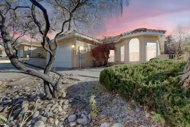 mediterranean / spanish home featuring a garage