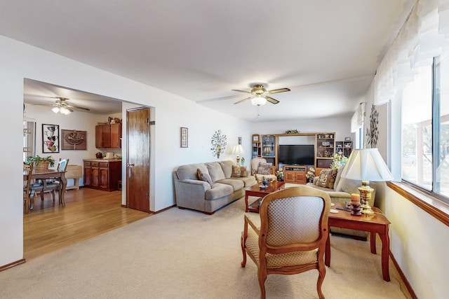 living room featuring ceiling fan and light hardwood / wood-style flooring