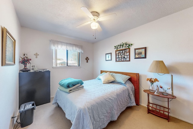 bedroom with light carpet, a textured ceiling, and ceiling fan