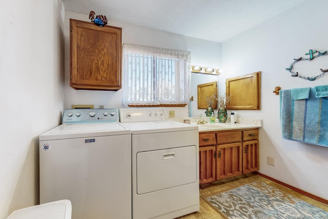 washroom with cabinets, sink, washer and dryer, a textured ceiling, and light hardwood / wood-style floors