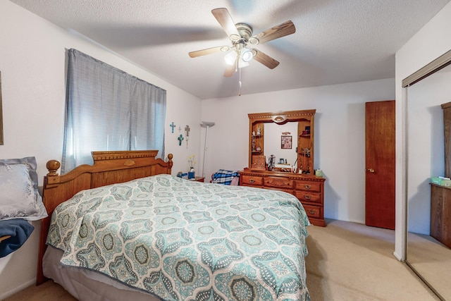 carpeted bedroom with a textured ceiling, a closet, and ceiling fan