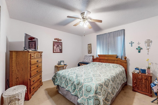 carpeted bedroom with ceiling fan and a textured ceiling