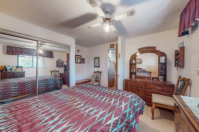 carpeted bedroom with a textured ceiling, a closet, and ceiling fan