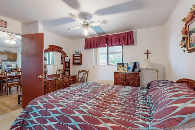 bedroom with wood-type flooring, a textured ceiling, and ceiling fan