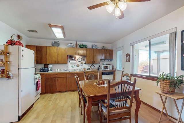 dining room with ceiling fan, light wood-type flooring, and sink