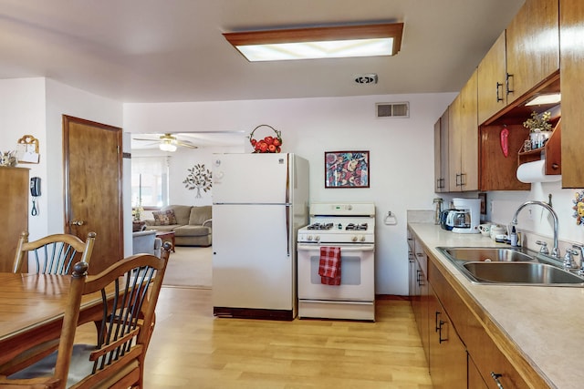 kitchen featuring ceiling fan, light wood-type flooring, white appliances, and sink