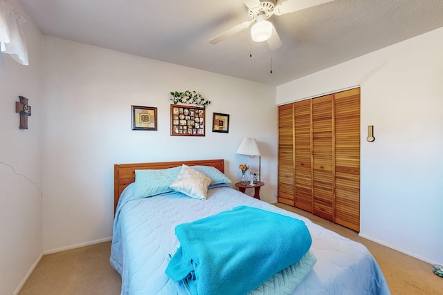 carpeted bedroom with ceiling fan and a closet