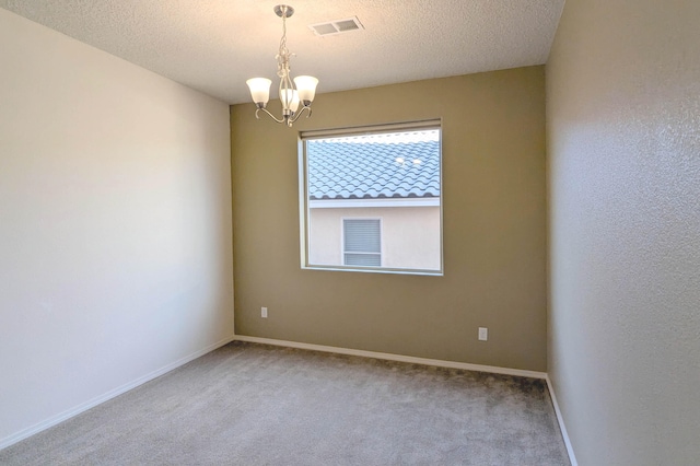 unfurnished room featuring light colored carpet, a chandelier, and a textured ceiling