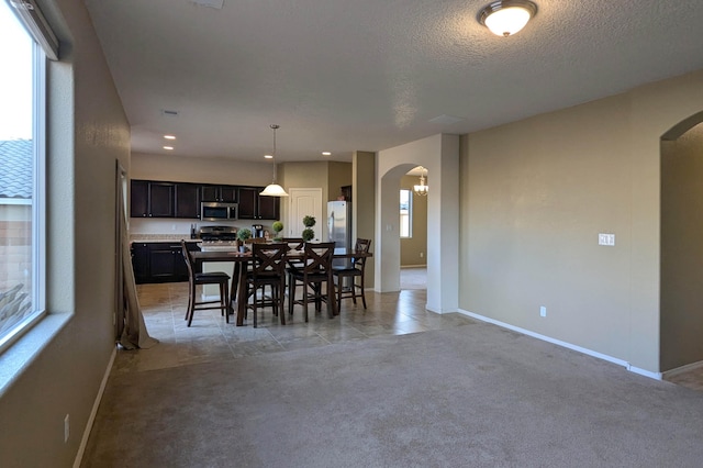 carpeted dining area featuring a textured ceiling