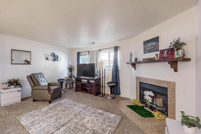 carpeted living room featuring a tiled fireplace