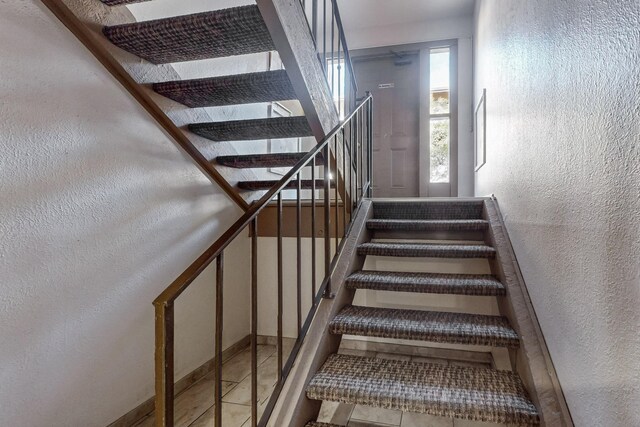 stairway with tile patterned floors