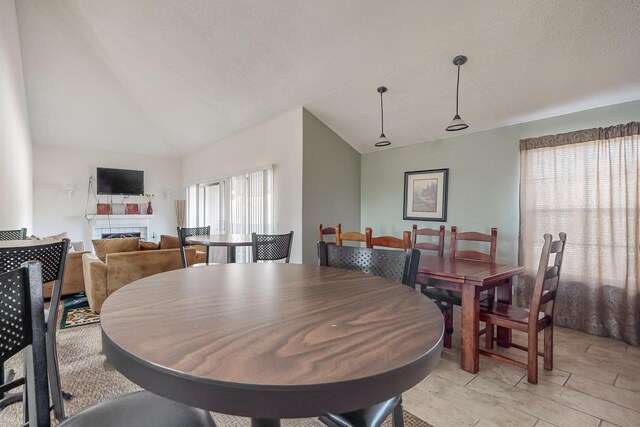 dining room featuring a textured ceiling and lofted ceiling