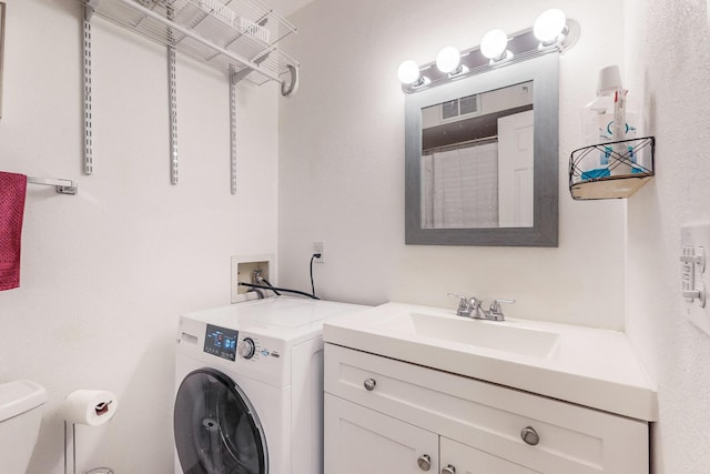 clothes washing area with sink and washer / dryer