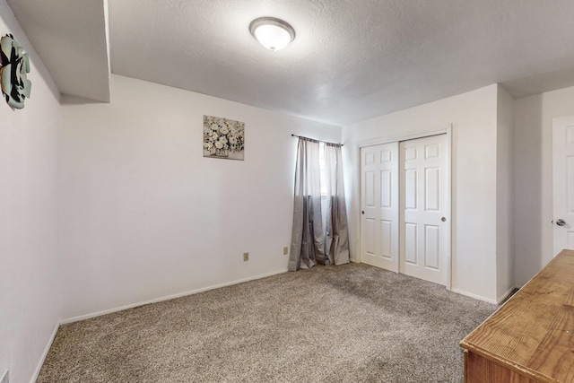 unfurnished bedroom with a closet, a textured ceiling, and carpet flooring