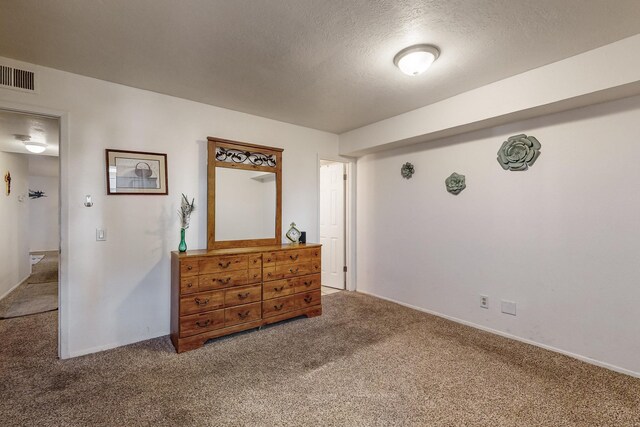 bedroom with carpet floors and a textured ceiling