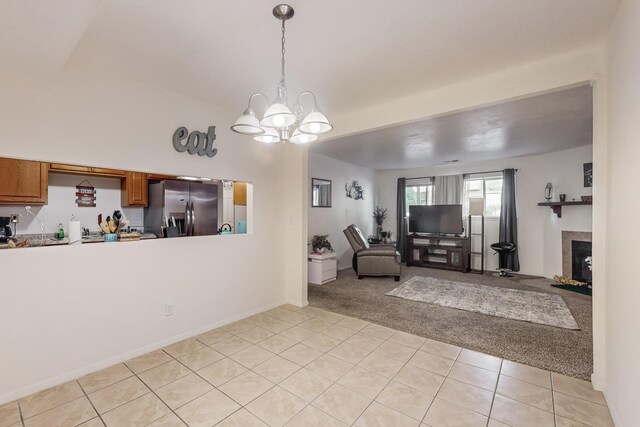 unfurnished living room with a notable chandelier and light tile patterned floors