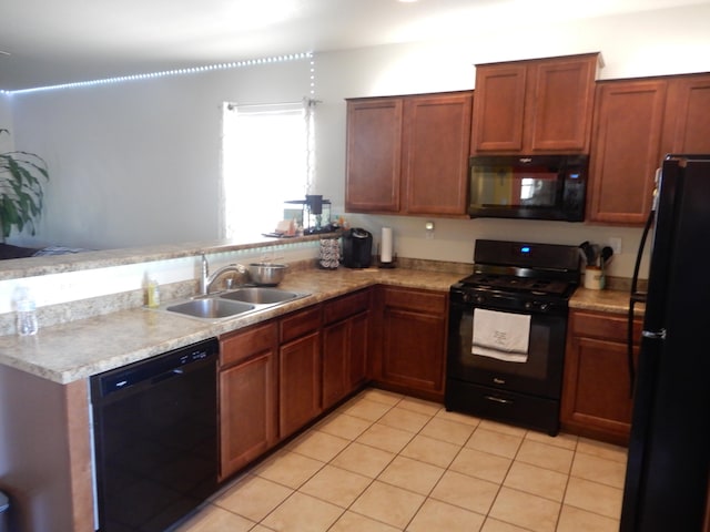 kitchen with kitchen peninsula, light tile patterned floors, sink, and black appliances