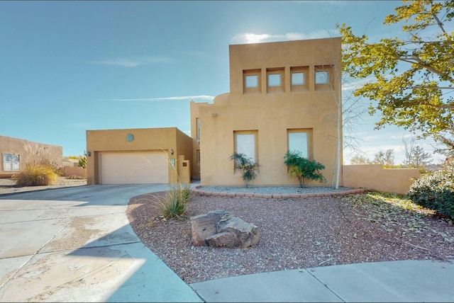 pueblo-style house featuring a garage