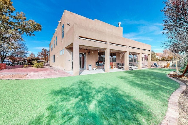 rear view of house with a lawn and a patio area