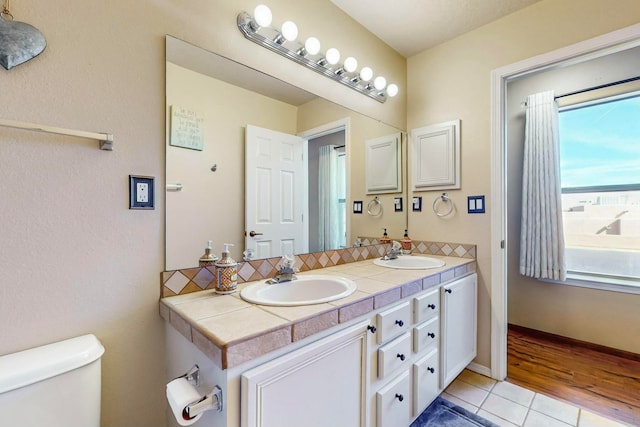 bathroom with tile patterned flooring, vanity, and toilet