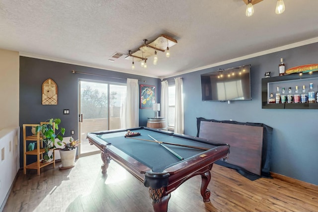 game room featuring billiards, ornamental molding, a textured ceiling, and hardwood / wood-style flooring