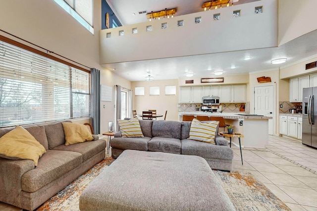 living room featuring a towering ceiling and light tile patterned flooring