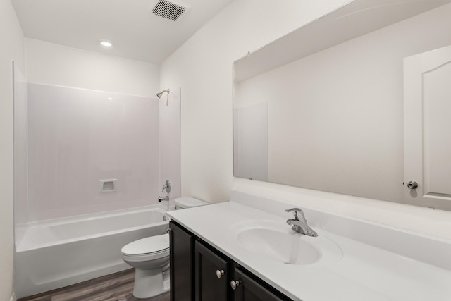 full bathroom with hardwood / wood-style flooring, vanity, shower / bath combination, and toilet