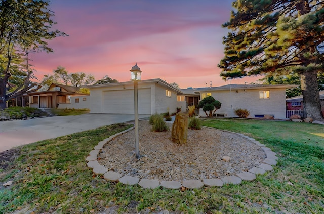 ranch-style home featuring a lawn and a garage