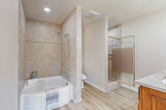 full bathroom with hardwood / wood-style floors, vanity, toilet, a textured ceiling, and independent shower and bath