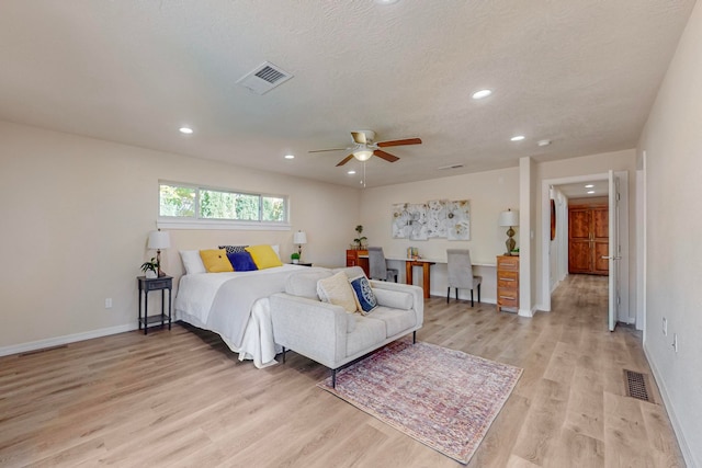 bedroom featuring a textured ceiling, light hardwood / wood-style floors, and ceiling fan