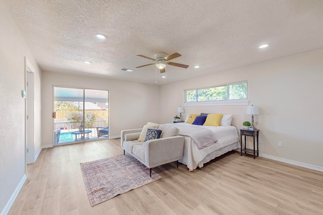 bedroom featuring access to outside, ceiling fan, light hardwood / wood-style flooring, and a textured ceiling