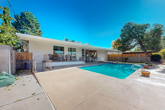 view of pool with a patio and a diving board