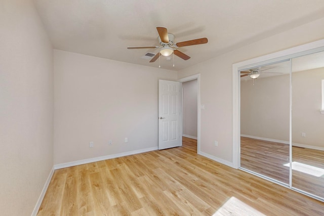 unfurnished bedroom featuring a closet, light hardwood / wood-style flooring, and ceiling fan