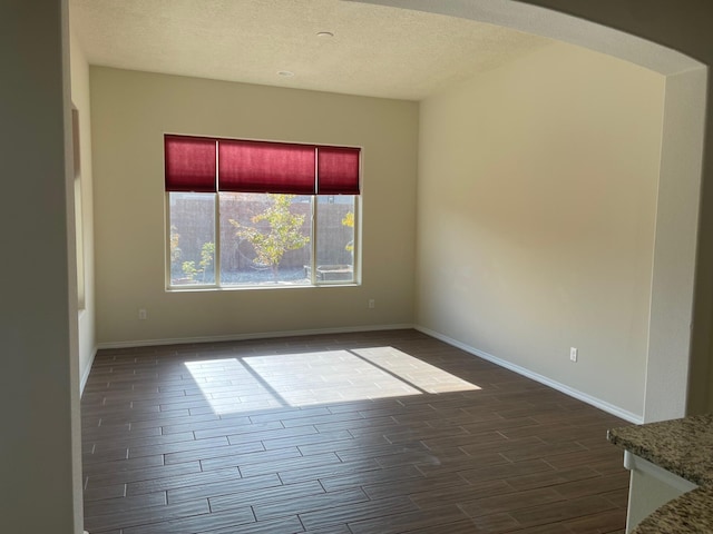 spare room with hardwood / wood-style floors and a textured ceiling