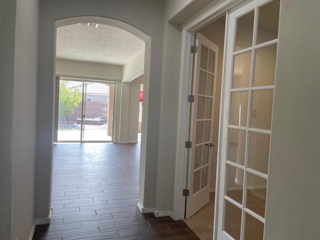 corridor featuring a textured ceiling and hardwood / wood-style flooring