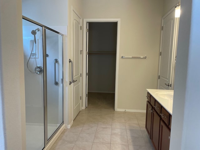 bathroom with tile patterned flooring, vanity, and walk in shower