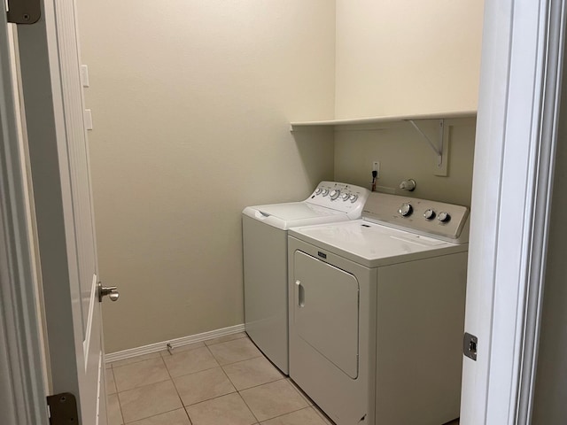 clothes washing area featuring light tile patterned flooring and independent washer and dryer