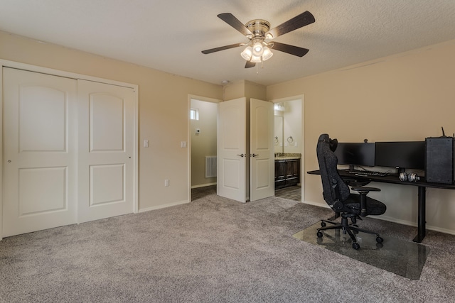 carpeted office with ceiling fan and a textured ceiling