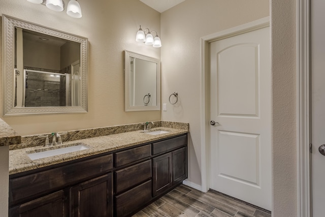 bathroom with hardwood / wood-style floors, vanity, and an enclosed shower