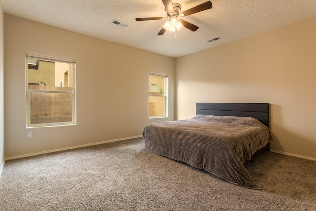 bedroom featuring a textured ceiling, carpet floors, and ceiling fan