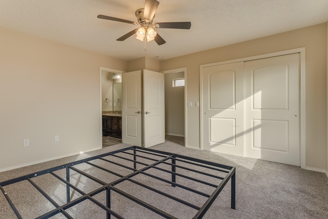 unfurnished bedroom with connected bathroom, ceiling fan, carpet floors, a textured ceiling, and a closet