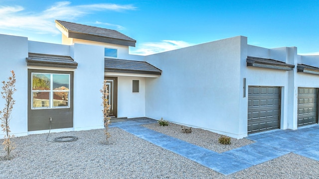 1109 11th St SE, Rio Rancho, NM 87124 - view of front of house featuring stucco siding, an attached garage, a tile roof, and driveway