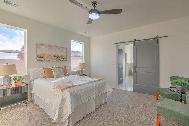 1109 11th St SE, Rio Rancho, NM 87124 - bedroom with a ceiling fan, a barn door, light colored carpet, and visible vents