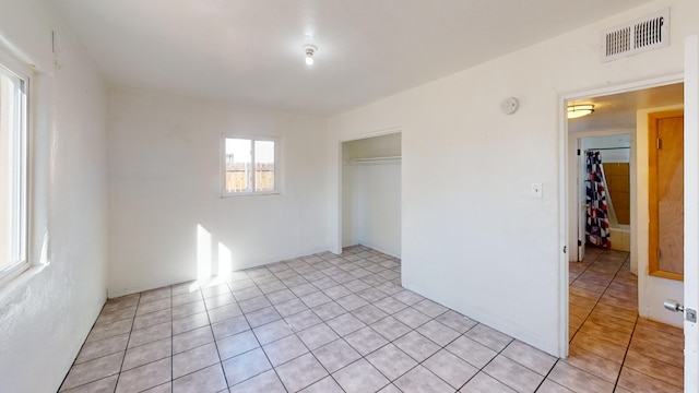 unfurnished bedroom with a closet and light tile patterned flooring