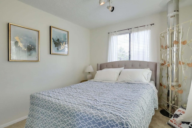 bedroom with light carpet and a textured ceiling