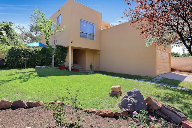 rear view of house with a garage and a lawn